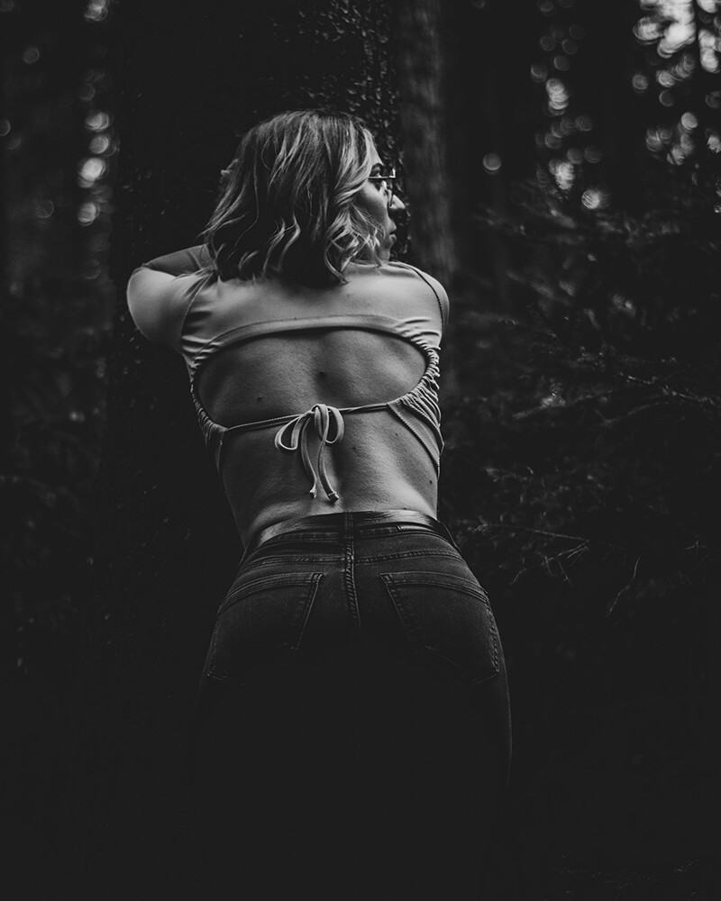 Natürliche Portraitfotografie einer Frau im Wald - aufgenommen in schwarz weiß